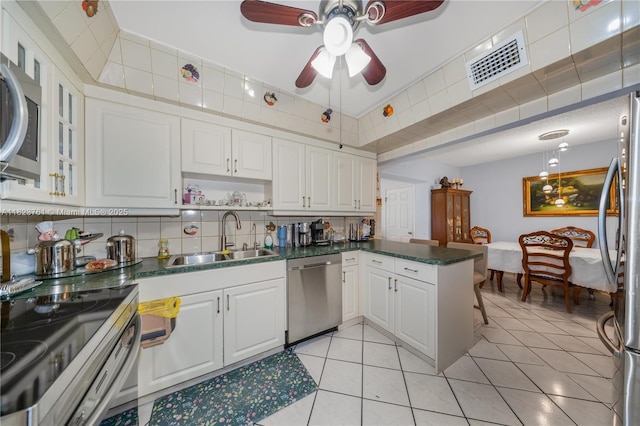 359 E 19th St, Hialeah, FL 33010 - kitchen featuring appliances with stainless steel finishes, white cabinetry, a peninsula, a ceiling fan, and light tile patterned flooring