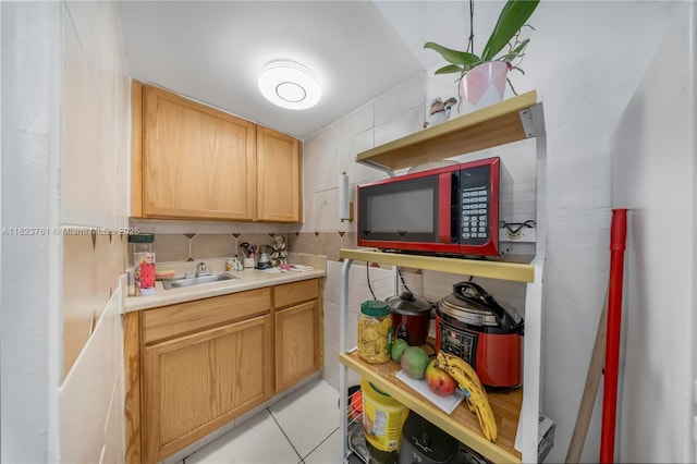 359 E 19th St, Hialeah, FL 33010 - kitchen with decorative backsplash, light countertops, light brown cabinetry, and light tile patterned floors