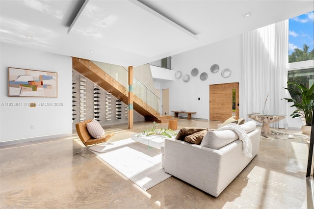 10620 SW 74th Ave, Pinecrest, FL 33156 - living room featuring finished concrete floors, stairway, and a towering ceiling