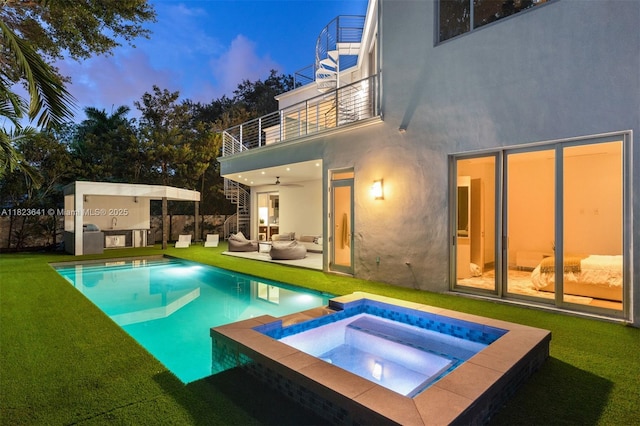 10620 SW 74th Ave, Pinecrest, FL 33156 - back of house at dusk featuring a balcony, stucco siding, an outdoor hangout area, a yard, and a patio
