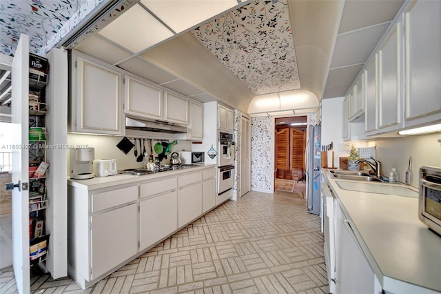 1800 NE 114th St Unit 604, Miami, FL 33181 - kitchen with cooktop, brick patterned floors, light countertops, double oven, and under cabinet range hood