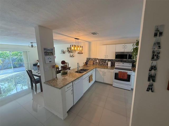 14251 SW 96th Ter Unit 14251, Miami, FL 33186 - kitchen featuring white appliances, a chandelier, white cabinets, decorative backsplash, and decorative light fixtures