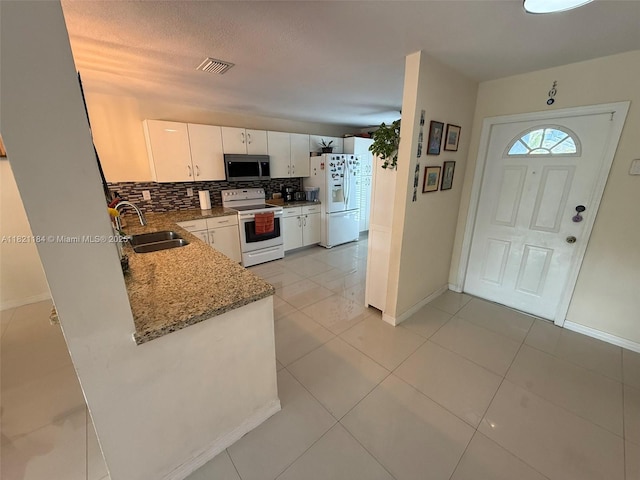 14251 SW 96th Ter Unit 14251, Miami, FL 33186 - kitchen featuring white appliances, tasteful backsplash, light stone countertops, white cabinetry, and light tile patterned floors