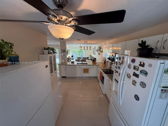 14251 SW 96th Ter Unit 14251, Miami, FL 33186 - kitchen featuring white appliances, ceiling fan, white cabinetry, light tile patterned floors, and a peninsula