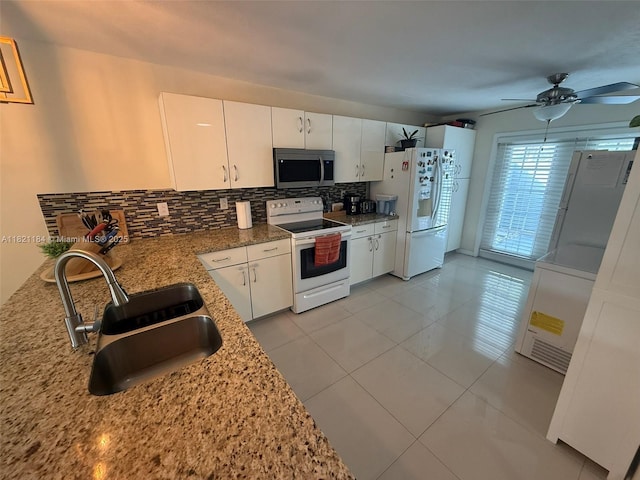 14251 SW 96th Ter Unit 14251, Miami, FL 33186 - kitchen featuring white appliances, backsplash, white cabinets, a ceiling fan, and light stone countertops