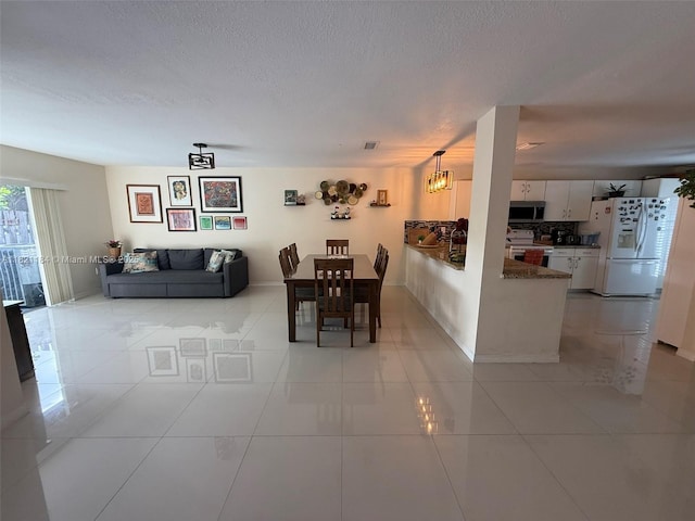 14251 SW 96th Ter Unit 14251, Miami, FL 33186 - dining area with light tile patterned floors, a textured ceiling, and a chandelier