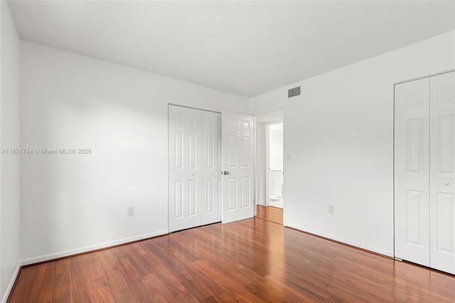 1912 Monroe St Unit 201, Hollywood, FL 33020 - unfurnished bedroom featuring wood finished floors and multiple closets
