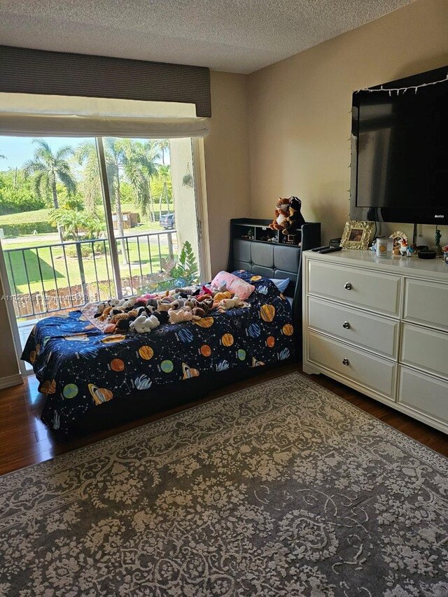 2423 NE 10th St Unit 154, Hallandale Beach, FL 33009 - bedroom with wood finished floors, access to outside, and a textured ceiling