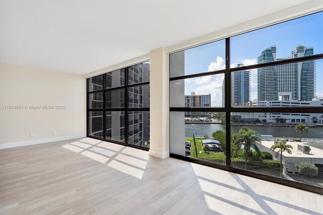 600 Parkview Dr Unit 624, Hallandale Beach, FL 33009 - spare room featuring a water view, wood finished floors, a view of city, and expansive windows