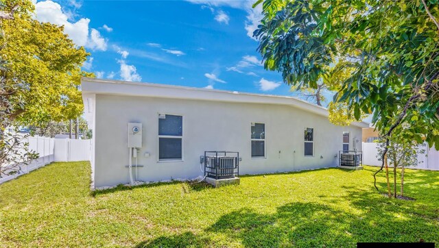 409 NW 4th Ave, Hallandale Beach, FL 33009 - rear view of property with stucco siding and a fenced backyard
