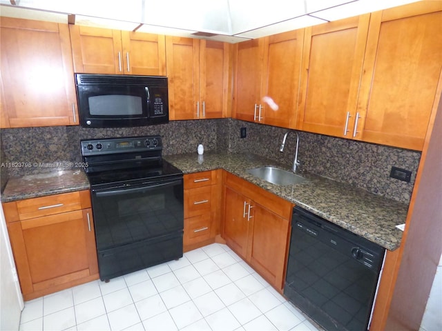 5005 Collins Ave Unit 202, Miami Beach, FL 33140 - kitchen with black appliances, dark stone counters, and brown cabinets