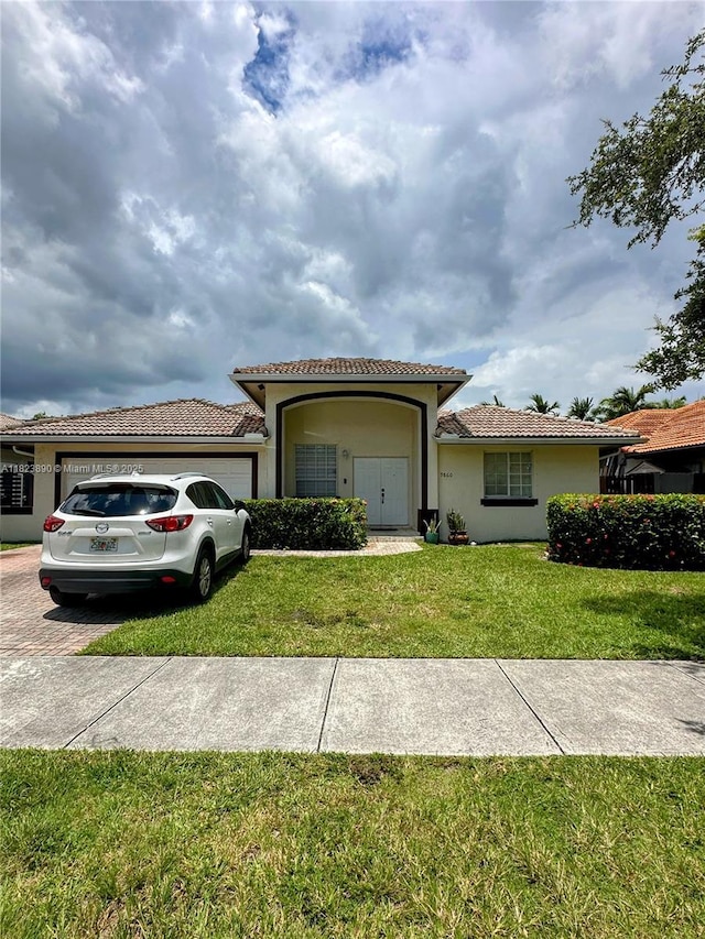 9860 SW 161st Ave, Miami, FL 33196 - view of front of house featuring stucco siding, a tiled roof, a garage, a front lawn, and driveway