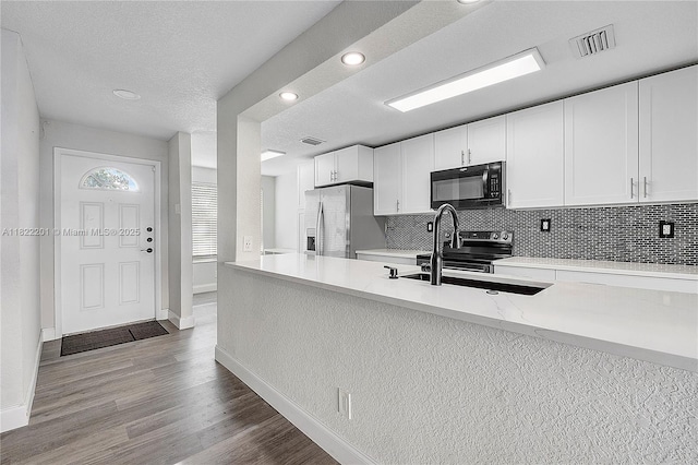 8239 NW 8th St Unit 3, Plantation, FL 33324 - kitchen with stainless steel appliances, decorative backsplash, wood finished floors, white cabinets, and recessed lighting