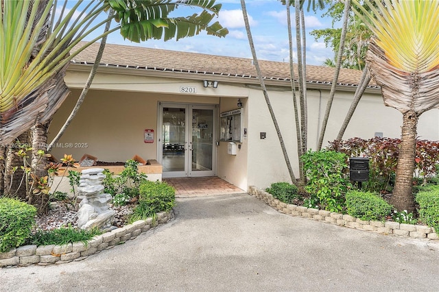 8239 NW 8th St Unit 3, Plantation, FL 33324 - property entrance featuring stucco siding, french doors, and a shingled roof
