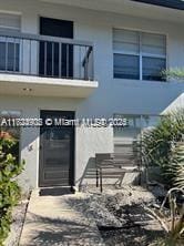 13648 Coconut Palm Ct Unit C, Delray Beach, FL 33484 - doorway to property with stucco siding and a balcony