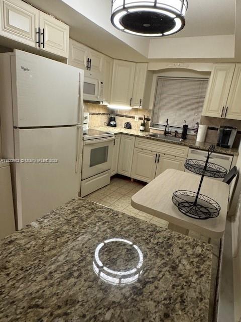 13648 Coconut Palm Ct Unit C, Delray Beach, FL 33484 - kitchen featuring white appliances, tasteful backsplash, and dark stone counters