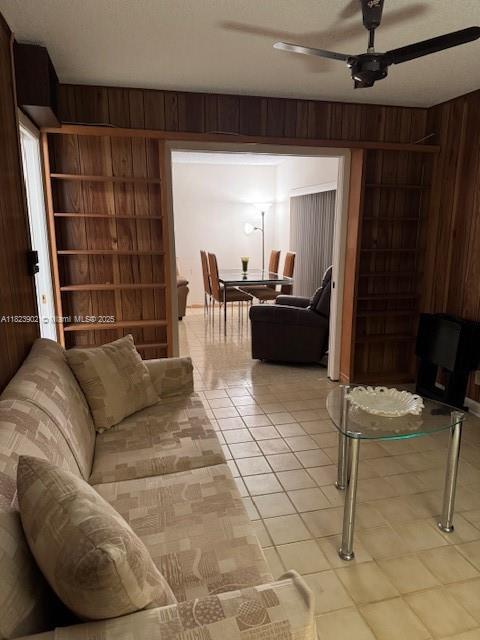 13648 Coconut Palm Ct Unit C, Delray Beach, FL 33484 - living room featuring wooden walls, a ceiling fan, light tile patterned floors, and built in shelves