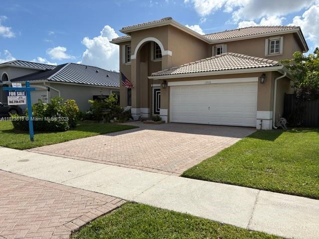 13933 SW 155th Ct, Miami, FL 33196 - view of front of home with stucco siding, a garage, decorative driveway, a front lawn, and a tile roof