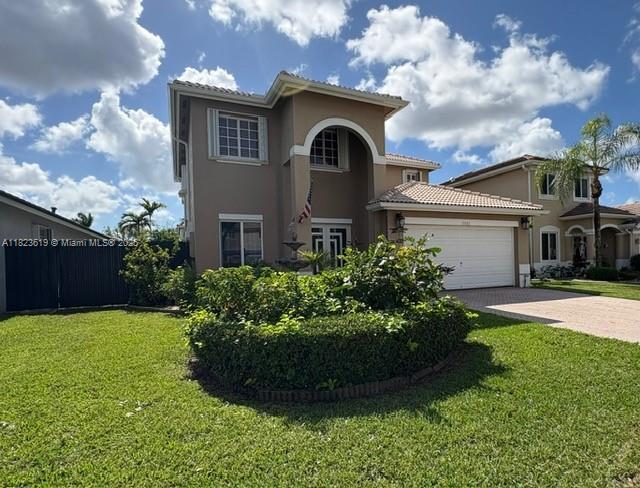 13933 SW 155th Ct, Miami, FL 33196 - mediterranean / spanish house featuring stucco siding, driveway, an attached garage, and a tile roof