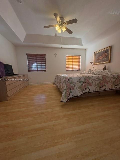 13933 SW 155th Ct, Miami, FL 33196 - bedroom featuring a tray ceiling, light wood-type flooring, and ceiling fan