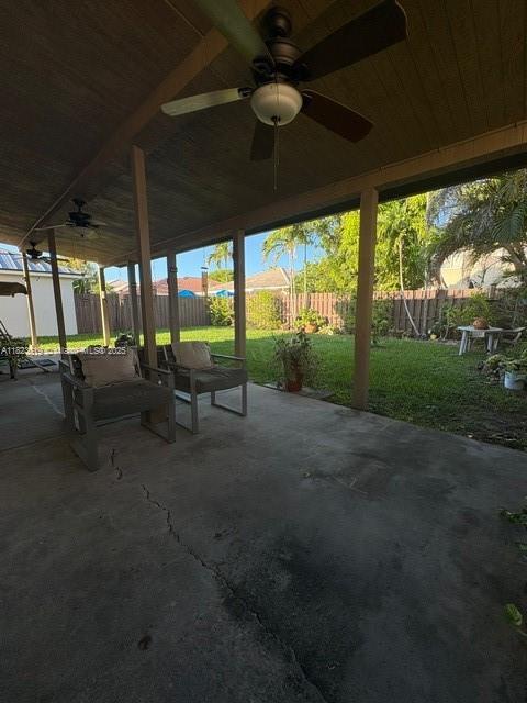 13933 SW 155th Ct, Miami, FL 33196 - fenced backyard with a ceiling fan, a patio area, and an outdoor structure