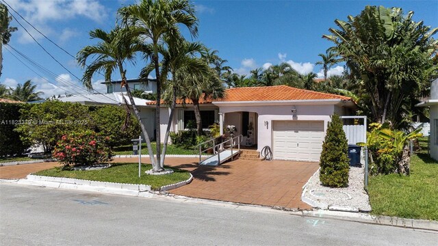 9064 Garland Ave, Surfside, FL 33154 - mediterranean / spanish home featuring a garage, stucco siding, a tile roof, and decorative driveway