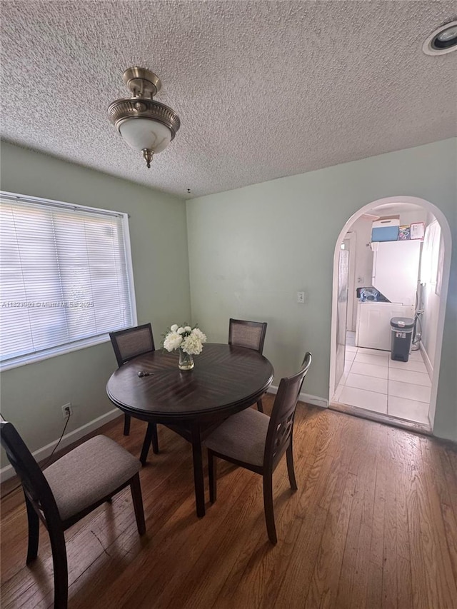 6413 Franklin St, Hollywood, FL 33024 - dining space featuring arched walkways, a textured ceiling, and wood-type flooring