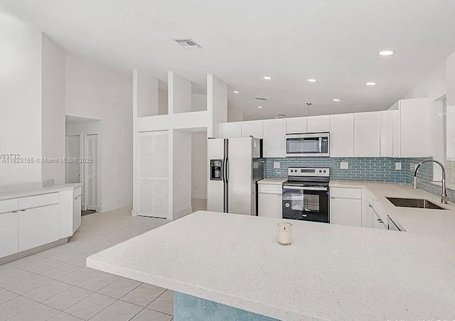9720 SW 154th Pl, Miami, FL 33196 - kitchen featuring stainless steel appliances, backsplash, light tile patterned flooring, white cabinetry, and recessed lighting