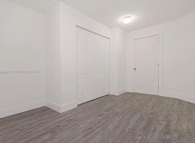 9720 SW 154th Pl, Miami, FL 33196 - unfurnished bedroom with wood finished floors, a textured ceiling, and a closet