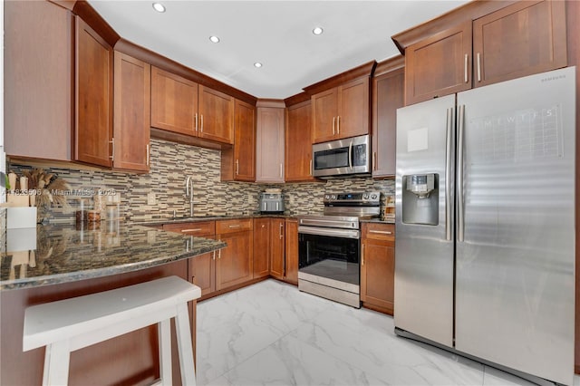 4445 SW 160th Ave Unit 102, Miramar, FL 33027 - kitchen with appliances with stainless steel finishes, dark stone countertops, brown cabinets, and recessed lighting
