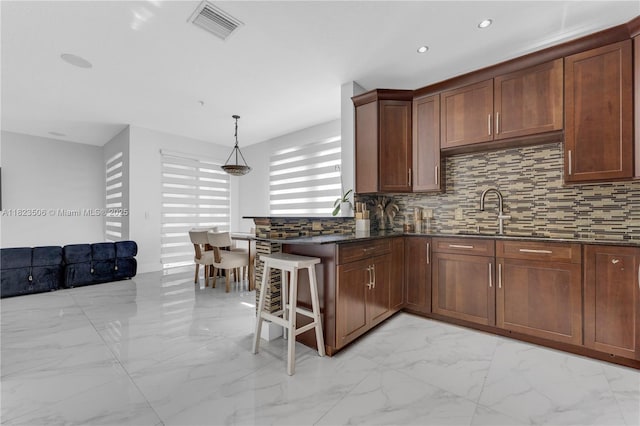 4445 SW 160th Ave Unit 102, Miramar, FL 33027 - kitchen featuring light marble finish flooring, backsplash, a peninsula, dark stone counters, and recessed lighting