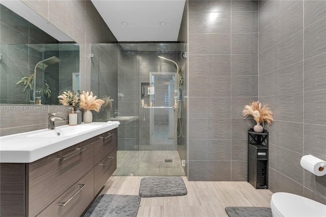 4445 SW 160th Ave Unit 102, Miramar, FL 33027 - bathroom featuring tile walls, vanity, a stall shower, and wood finished floors