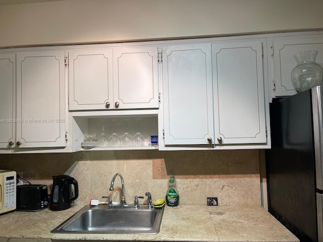 5 Island Ave Unit 5G, Miami Beach, FL 33139 - kitchen with freestanding refrigerator, white cabinets, tasteful backsplash, and white microwave
