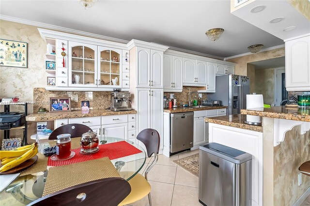 250 174th St Unit 1704, Sunny Isles Beach, FL 33160 - kitchen featuring appliances with stainless steel finishes, decorative backsplash, ornamental molding, white cabinetry, and glass insert cabinets