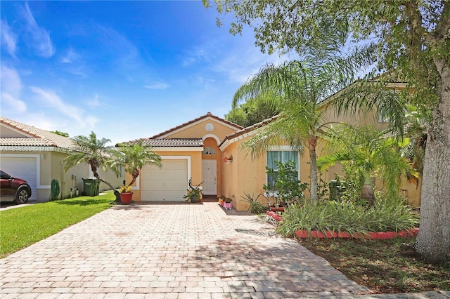 1585 SE 20th Rd, Homestead, FL 33035 - view of front of house featuring decorative driveway, a garage, stucco siding, and a tiled roof