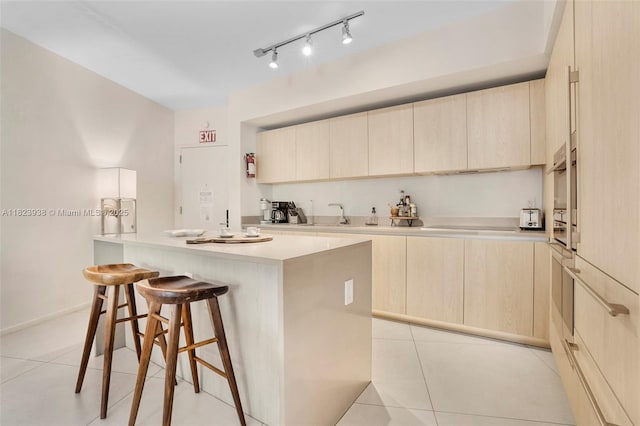 4111 S Ocean Dr Unit 3709, Hollywood, FL 33019 - kitchen with light brown cabinets, a breakfast bar, a center island, light countertops, and light tile patterned floors