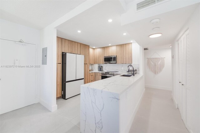 1965 S Ocean Dr Unit 6F, Hallandale Beach, FL 33009 - kitchen with appliances with stainless steel finishes, modern cabinets, a peninsula, light stone counters, and recessed lighting