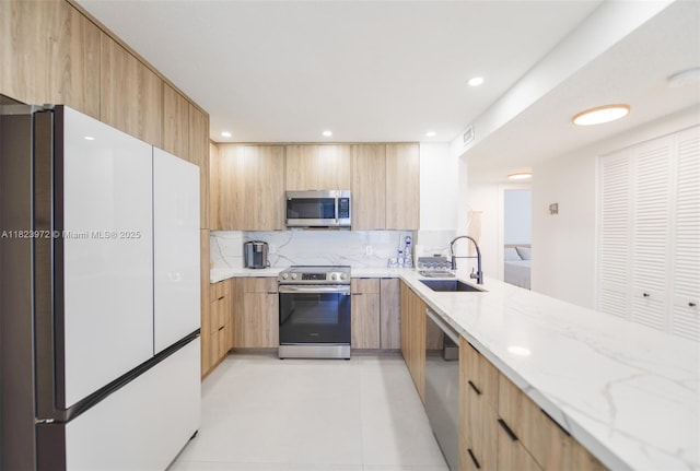 1965 S Ocean Dr Unit 6F, Hallandale Beach, FL 33009 - kitchen featuring stainless steel appliances, light brown cabinetry, modern cabinets, decorative backsplash, and light stone counters