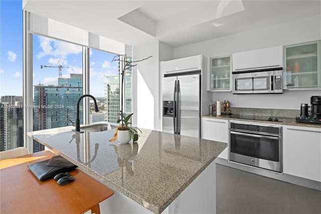 888 Biscayne Blvd Unit 4801, Miami, FL 33132 - kitchen with stainless steel appliances, white cabinets, a breakfast bar, and modern cabinets