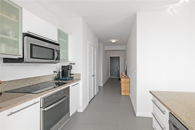 888 Biscayne Blvd Unit 4801, Miami, FL 33132 - kitchen with stainless steel appliances, white cabinets, glass insert cabinets, and light stone counters