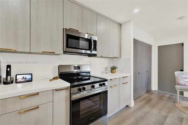 9905 NW 52nd Ln, Doral, FL 33178 - kitchen with appliances with stainless steel finishes, modern cabinets, light countertops, backsplash, and recessed lighting