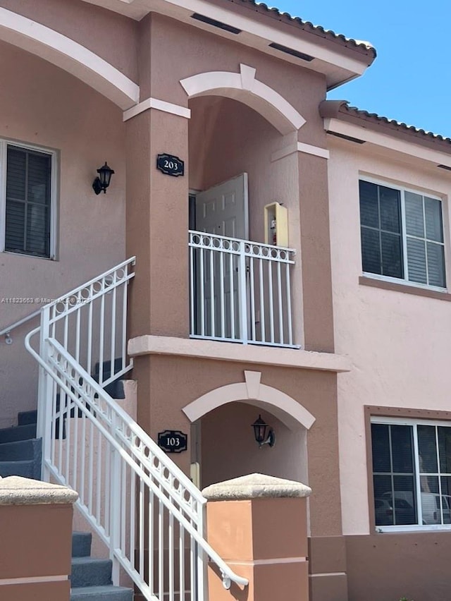 1250 SE 28th Ct Unit 203, Homestead, FL 33035 - entrance to property with stucco siding, a balcony, and a tiled roof