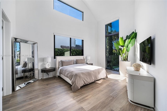 450 W 62nd St, Miami Beach, FL 33140 - bedroom with high vaulted ceiling, wood finished floors, multiple windows, and access to exterior