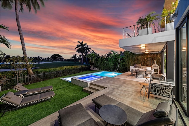 450 W 62nd St, Miami Beach, FL 33140 - pool at dusk featuring an in-ground hot tub, outdoor dining space, and a wooden deck