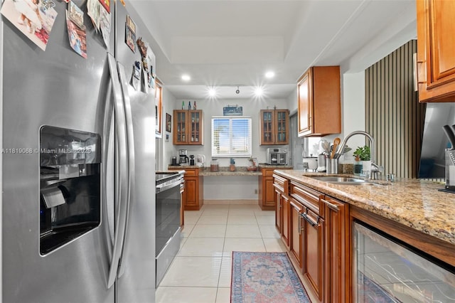 131 NW 31st Ct, Pompano Beach, FL 33064 - kitchen featuring appliances with stainless steel finishes, brown cabinetry, light tile patterned floors, wine cooler, and a raised ceiling