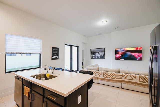 14659 SW 23rd Ter, Miami, FL 33175 - kitchen with light tile patterned floors, light countertops, stainless steel dishwasher, open floor plan, and freestanding refrigerator