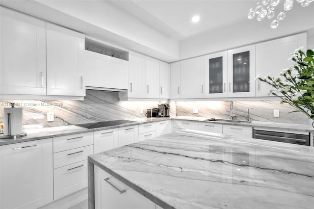 333 Las Olas Way Unit 804, Fort Lauderdale, FL 33301 - kitchen with black electric cooktop, backsplash, light stone countertops, white cabinets, and recessed lighting