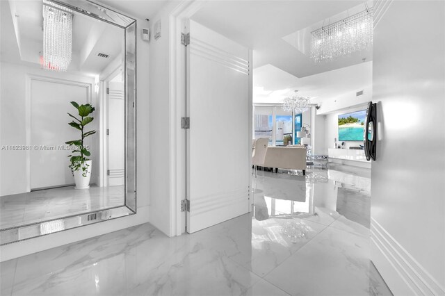 333 Las Olas Way Unit 804, Fort Lauderdale, FL 33301 - hall featuring a chandelier and marble tiled flooring