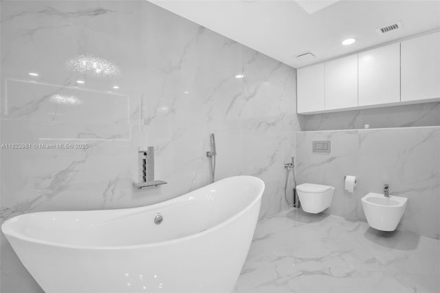 333 Las Olas Way Unit 804, Fort Lauderdale, FL 33301 - bathroom featuring marble tiled floors, a freestanding tub, a bidet, and tile walls