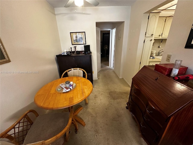 dining space with light colored carpet and ceiling fan